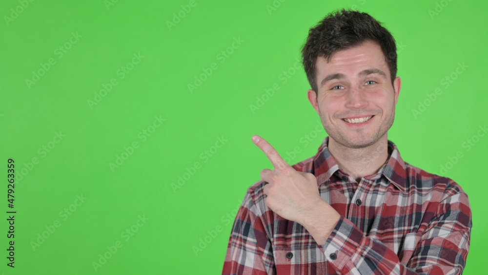 Portrait of Young Man Pointing Towards Product, Green Chroma Screen Portrait of Young Man Pointing Towards Product, Green Chroma Screen