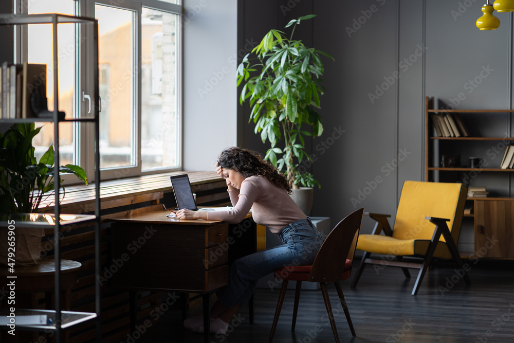 Work fatigue. Young woman freelancer feeling tired, exhausted and unproductive while sitting at her workplace at home, photo of overworked remote female employee. Emotional burnout of employees Work fatigue. Young woman freelancer feeling tired, exhausted and unproductive while sitting at her workplace at home, photo of overworked remote female employee. Emotional burnout of employees