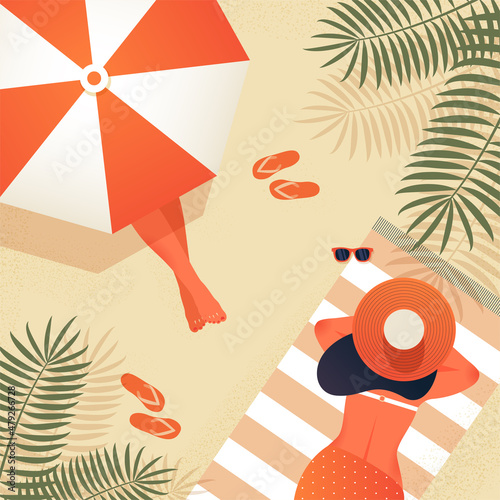 Two young women sunbathe on the beach