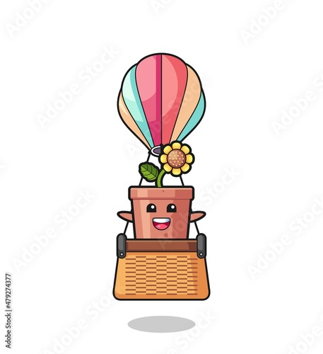 Obraz na plátne sunflower pot mascot riding a hot air balloon