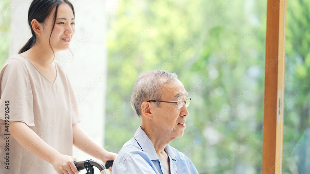 Fototapeta premium 車椅子を押す女性 ヤングケアラー