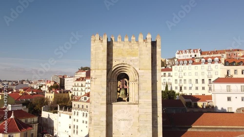 Up and away drone flight over the belfry of the Catedral Sé Patriarcal Igreja de Santa Maria Maior in Lisbon Portugal Alfama Europe ob a blue sky day photo
