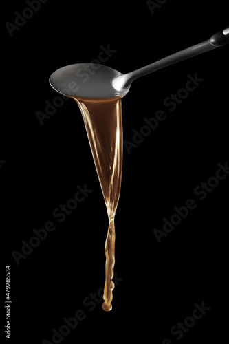 Dipper pouring noodle soup isolated on black background