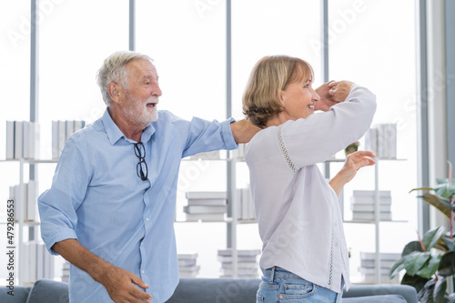 Happy senior couple family, romantic caucasians mature, adult lover, retired husband, wife having fun, enjoying while spending time dancing together in living room at home. smiling elderly man, woman.