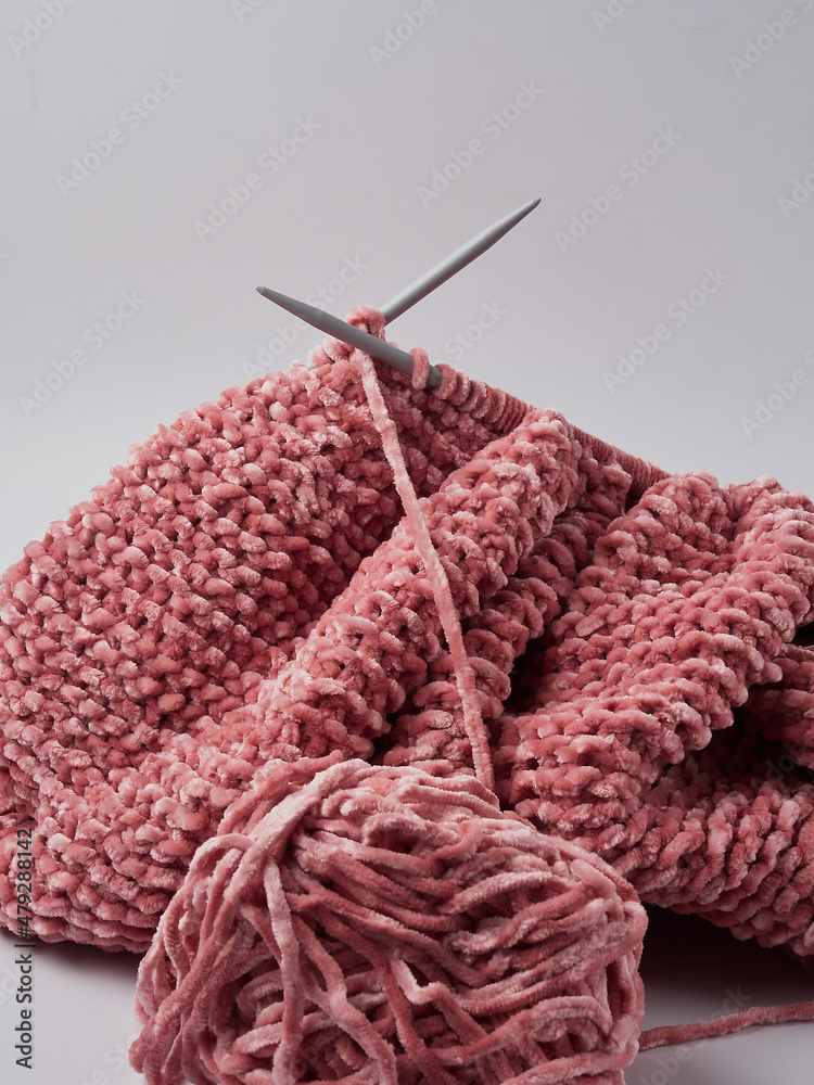 Fototapeta premium Wool yarn in different colors with wooden double point needles. The needles are being used for knitting socks, mittens or other projects joined in the round.