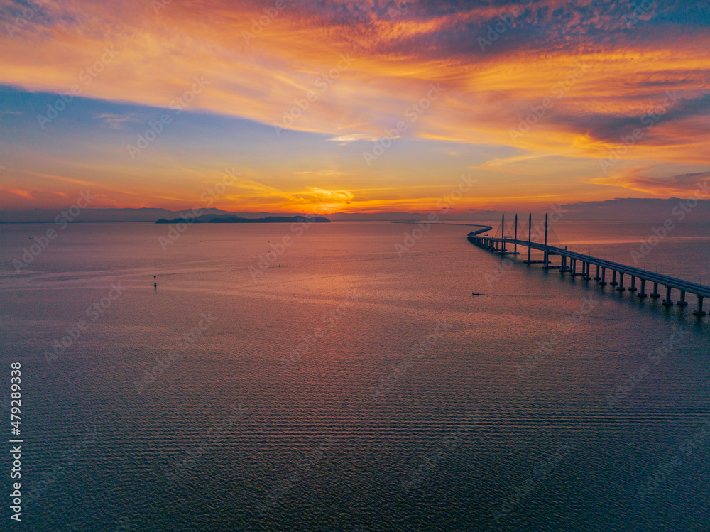 View of the bridge at sunrise which stands on the sea and connects the island and the mainland. It is the longest bridge in Malaysia