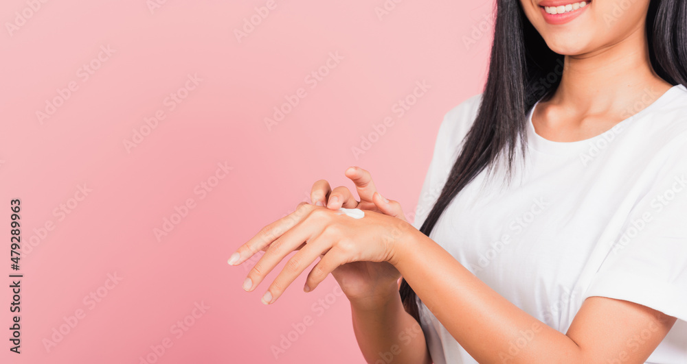 Portrait of Asian beautiful young woman applying lotion cosmetic moisturizer cream on her behind the palm skin back hand, studio shot isolated on pink background, Hygiene skin body care concept Portrait of Asian beautiful young woman applying lotion cosmetic moisturizer cream on her behind the palm skin back hand, studio shot isolated on pink background, Hygiene skin body care concept