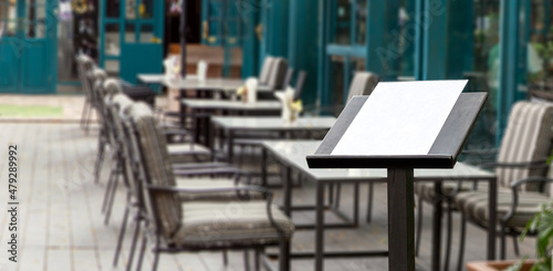 blank food menu on wood podiuem front of outdoor restaurant