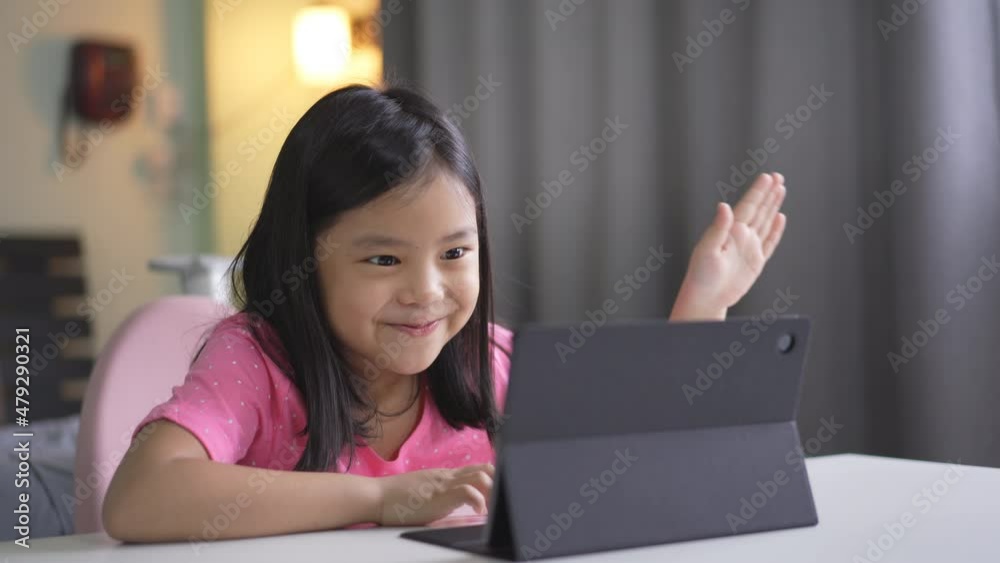 Asian child smile laugh to doing gestures on computer tablet or kid girl student enjoy active and talking fun on video call learning to study online class or person learn from home school in bedroom Asian child smile laugh to doing gestures on computer tablet or kid girl student enjoy active and talking fun on video call learning to study online class or person learn from home school in bedroom