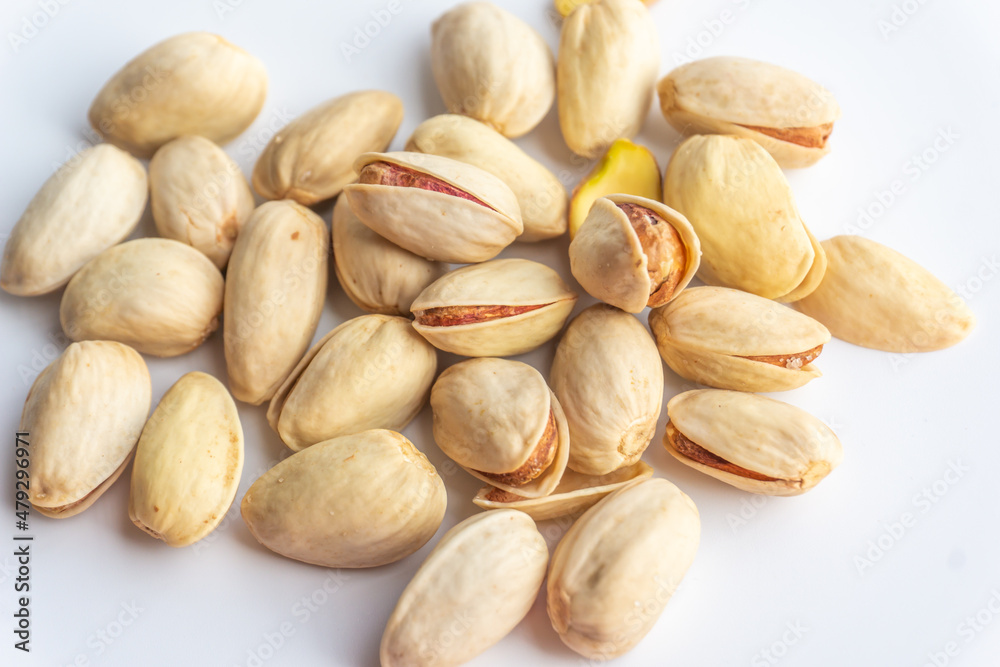 Pistachio nuts isolated on white background. A pile of salted roasted pistachios- an excellent source of protein, antioxidants, and fiber. Pistachio nuts isolated on white background. A pile of salted roasted pistachios- an excellent source of protein, antioxidants, and fiber.