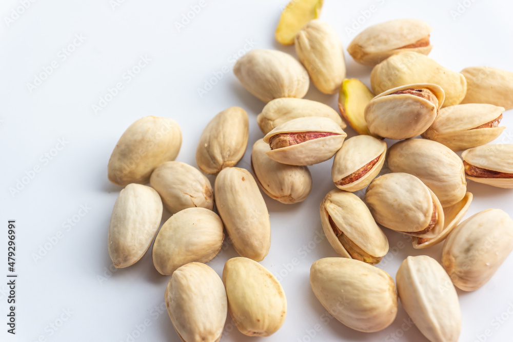 Pistachio nuts isolated on white background. A pile of salted roasted pistachios- an excellent source of protein, antioxidants, and fiber. Pistachio nuts isolated on white background. A pile of salted roasted pistachios- an excellent source of protein, antioxidants, and fiber.