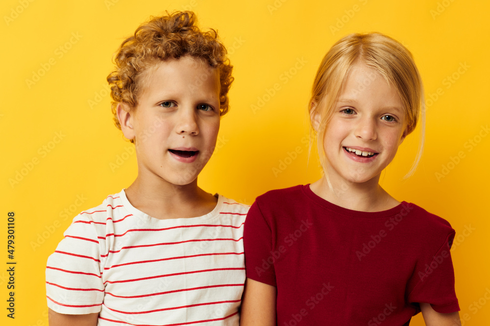 Portrait of cute children standing side by side posing childhood emotions yellow background Portrait of cute children standing side by side posing childhood emotions yellow background