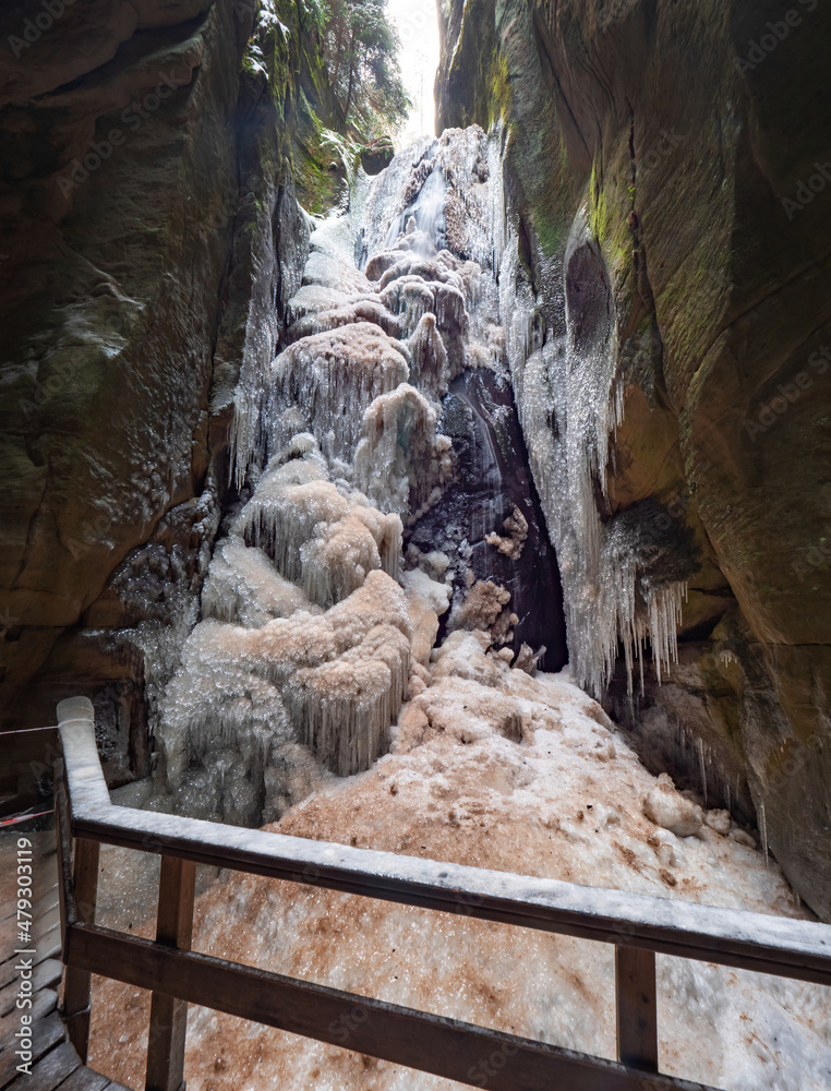 Massive iccicle of frozen Great waterfall in The Rocky town in Adrspach - National Nature Reserve in the Czech Republic, E