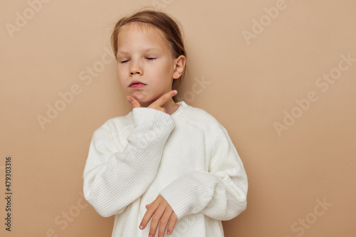 Portrait of happy smiling child girl in white sweater posing hand gestures childhood unaltered
