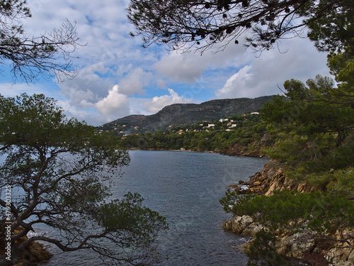 Beautiful view of the rocky mediterranean coast near town La Lavandou at the French Riviera, France on cloudy day in autumn season with trees.