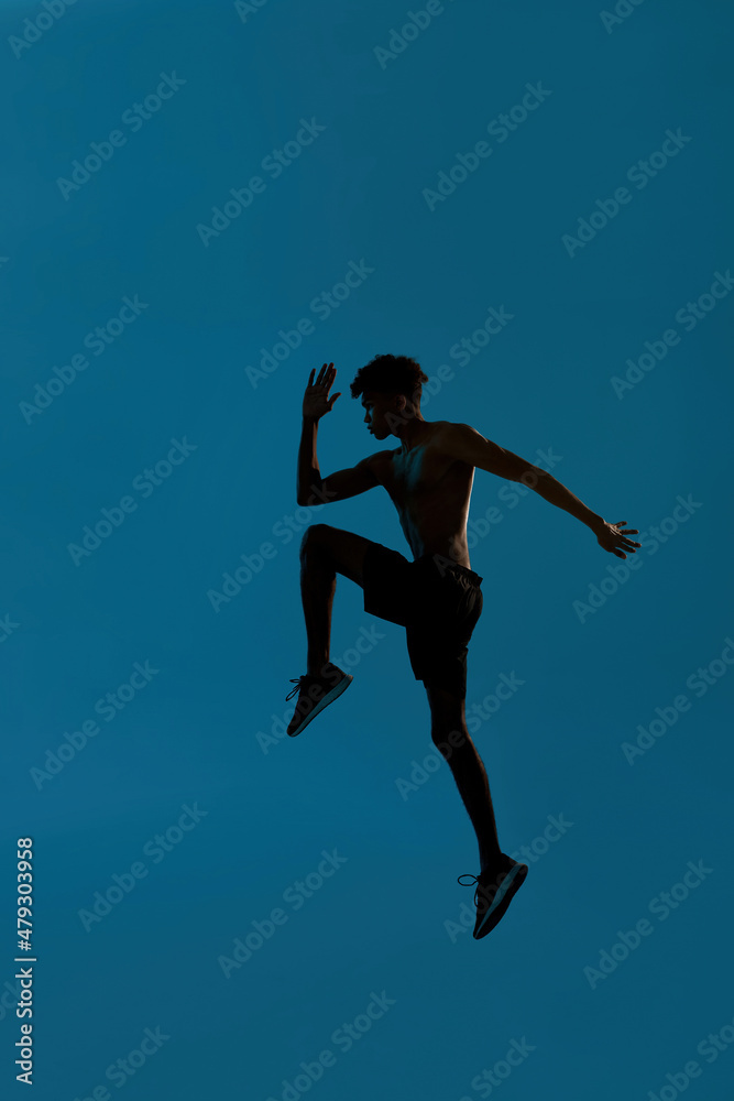 Side view of black serious sportsman jumping