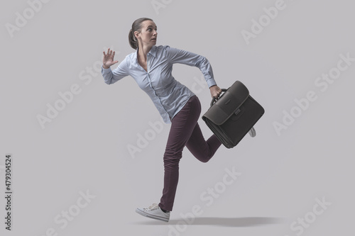 Scared businesswoman running away from a danger photo
