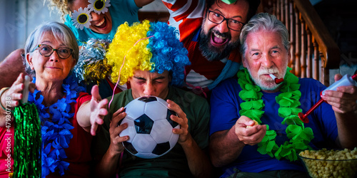 Group of football fans at home enjoy and exult for team success - world championship 2022 television concept - family watching soccer on television at home and have fun together in friendship photo