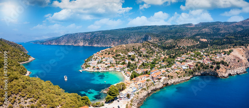 Panoramic aerial view of the little village of Assos on the island of Kefalonia, Greece, with emerald, calm sea and cloudy sky