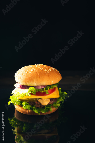 Homemade beef burgers and french fries on dark background.