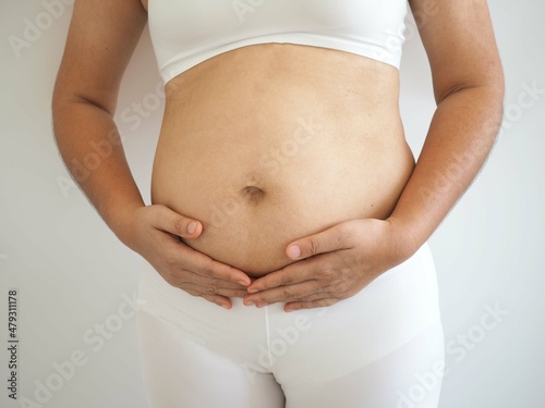 Pregnant woman touching her belly with hands. closeup photo, blurred.