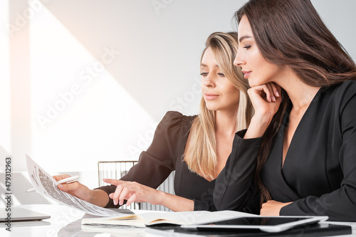 Young attractive businesswomen work together talking about new profitable contract