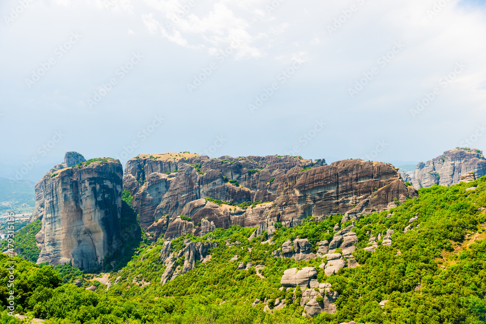 Huge gray rocks Meteors in Greece among green mountain forest