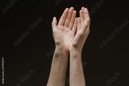 Praying hands to God in the dark. Woman hands reaching out to God or for help in barokko style
