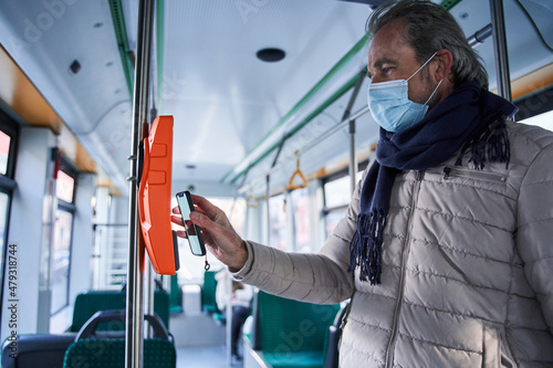 Senior caucasian man in protective medical mask in public transport bus