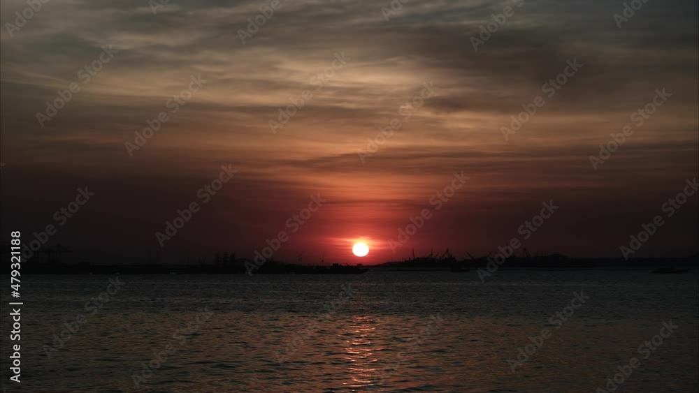 The setting sun in the evening when the sky is purple in the magic hour. at the industrial port timelapse The setting sun in the evening when the sky is purple in the magic hour. at the industrial port timelapse