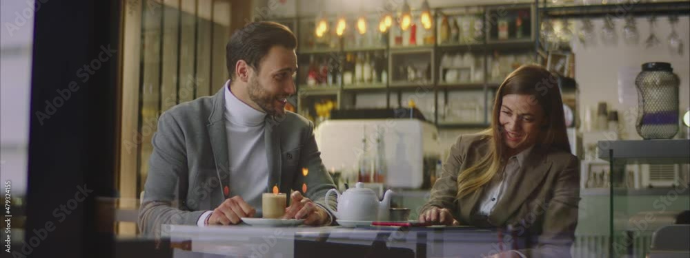 Caucasian pair spending time together. Sitting at table in cosy cafe. Speaking, smiling and having fun. Caucasian pair spending time together. Sitting at table in cosy cafe. Speaking, smiling and having fun.