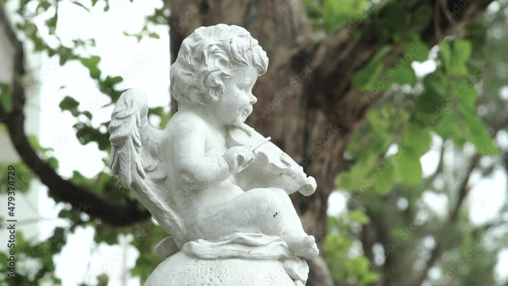 Statue white cupid boy figure playing violin in garden Statue white cupid boy figure playing violin in garden