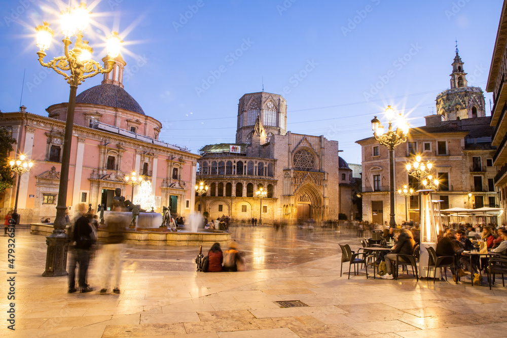 Obraz premium VALENCIA , SPAIN - DECEMBER 6, 2021: Square of Saint Mary's with Valencia Cathedral Temple, Basilica de la nuestra senora de los desamparados and the rio tura fountain in old town.
