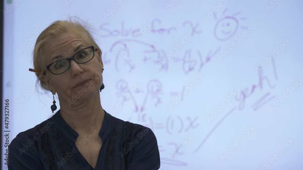 Portrait of mature frustrated woman teacher in front of an interactive whiteboard in a classroom. Portrait of mature frustrated woman teacher in front of an interactive whiteboard in a classroom.