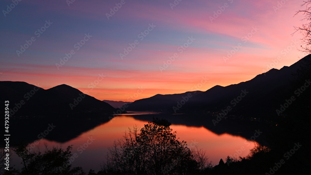 Magnifico tramonto sul lago, con cielo colorato di blu, rosa, giallo e rosso