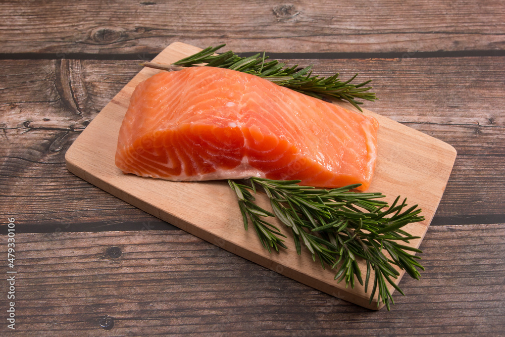 red salted fish on a cutting board with rosemary and lemon red salted fish on a cutting board with rosemary and lemon
