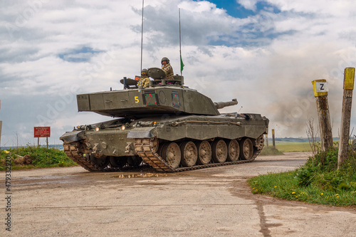 close up of commander and gunner atop a british army challenger 2 main battle tank in action on exercise on Salisbury Plain military training area, Wiltshire UK