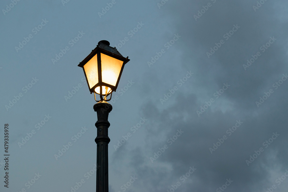 Silhouette of a street lamp in the cloudy evening