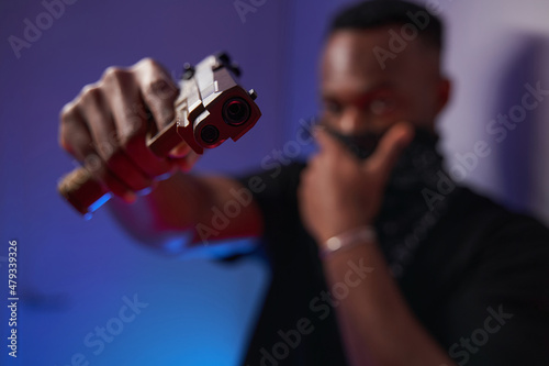 Male multiethnic American directing handgun into camera