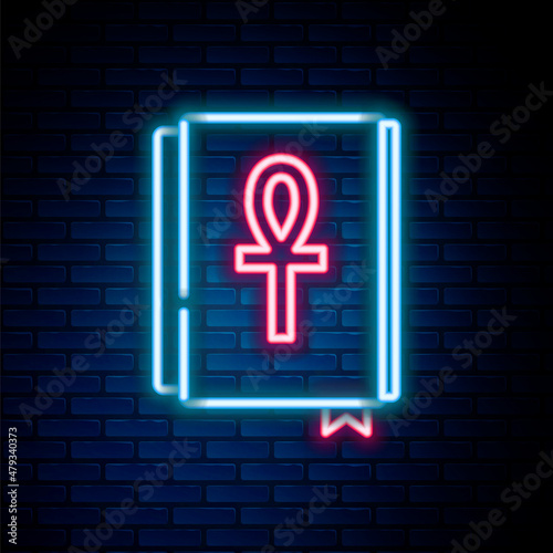 Glowing neon line Cross ankh book icon isolated on brick wall background. Colorful outline concept. Vector