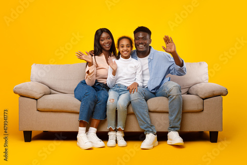 African American family waving hands at camera at studio