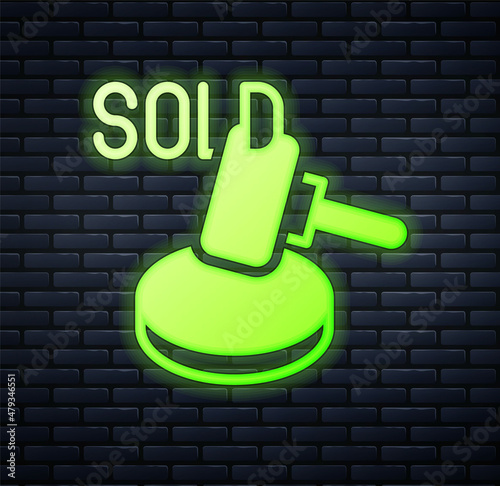 Glowing neon Auction hammer icon isolated on brick wall background. Gavel - hammer of judge or auctioneer. Bidding process, deal done. Auction bidding. Vector