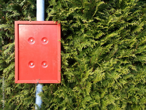 Leere rote Plastiktafel vor grüner Hecke  an einer verwaisten Bushaltestelle in Oerlinghausen bei Bielefeld am Hermannsweg im Teutoburger Wald in Ostwestfalen-Lippe photo