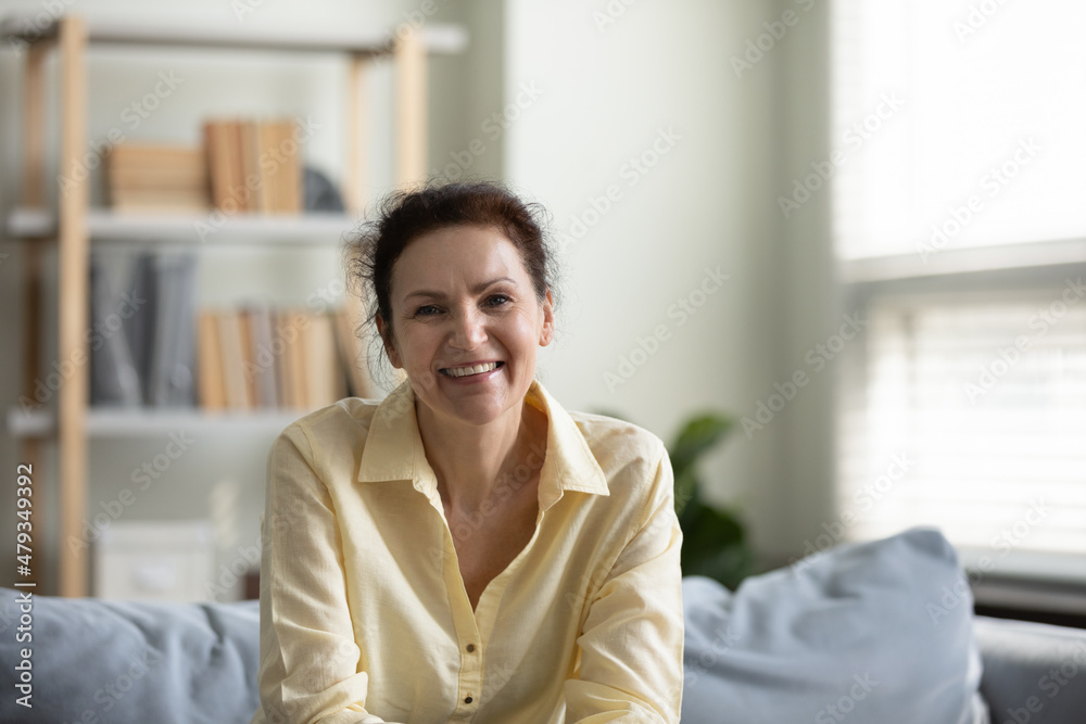 Portrait of happy smiling mature old woman sitting on cozy couch, holding video call distant conversation looking at camera, communicating distantly spending leisure weekend time alone at home. Portrait of happy smiling mature old woman sitting on cozy couch, holding video call distant conversation looking at camera, communicating distantly spending leisure weekend time alone at home.