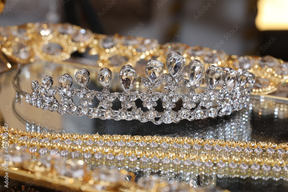 diamond-studded tiara or crown in a reflective tray diamond-studded tiara or crown in a reflective tray