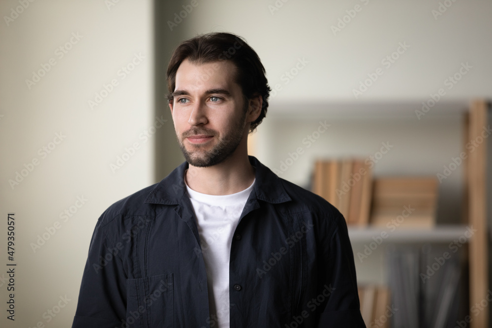 Happy dreamy handsome young 30s man in casual clothes looking in distance, visualizing future, imagining career opportunities, posing at home, property ownership, real estate services concept. Happy dreamy handsome young 30s man in casual clothes looking in distance, visualizing future, imagining career opportunities, posing at home, property ownership, real estate services concept.