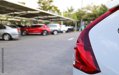 Closeup of rear, back car-light of white car parking in outdoor parking area.