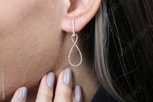 Jewelry, earrings in a beautiful girl's ear, women's accessories, gold earrings, earrings with stones, special diamonds