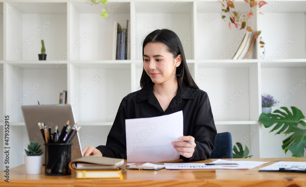 Successful businesswoman holding document and working with computer laptop. Successful businesswoman holding document and working with computer laptop.