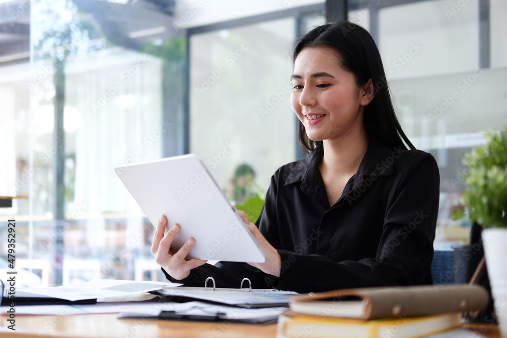 Attractive young businesswoman sitting in modern office and using digital tablet. Attractive young businesswoman sitting in modern office and using digital tablet.